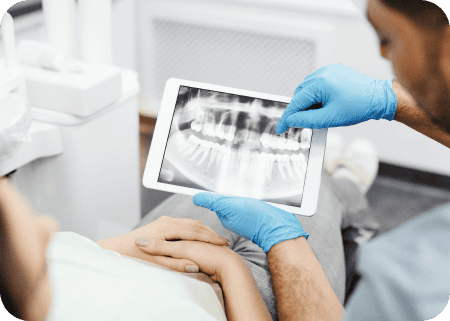 doctor explaining dental radiograph on tablet to patient