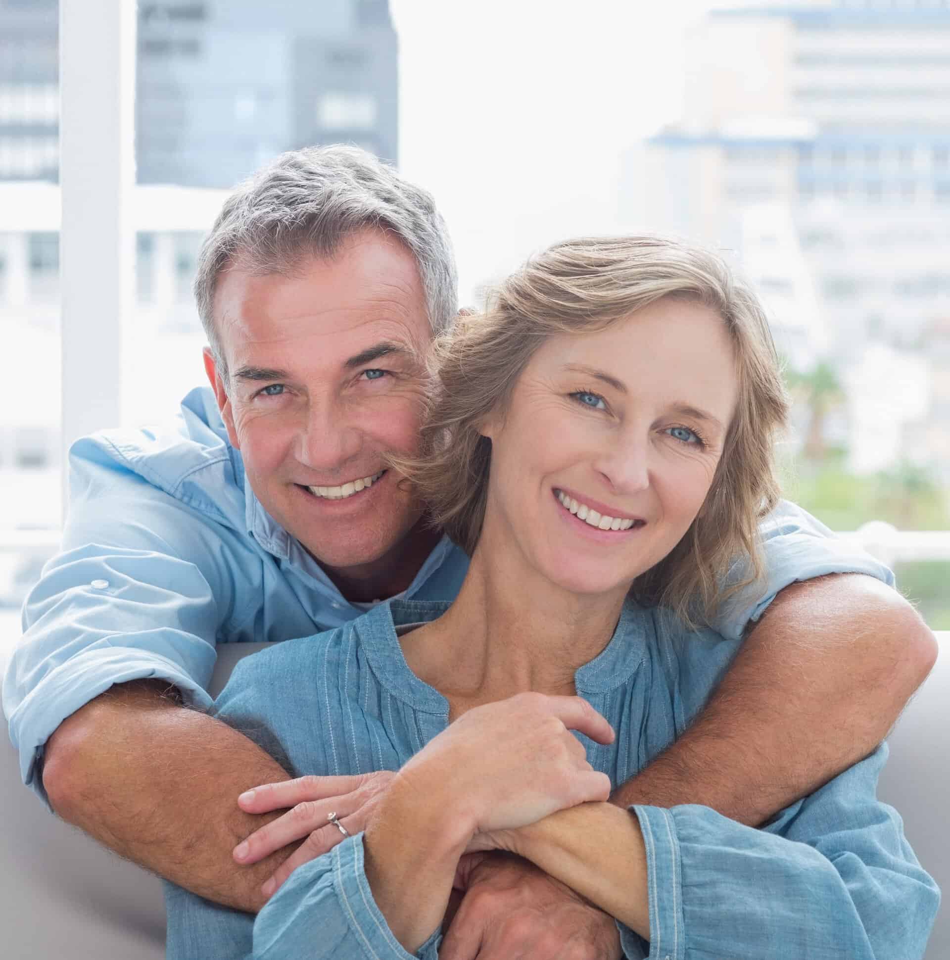 middle aged couple with husband hugging his wife on the couch